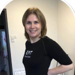 Frau trägt EFIT Electrofitness Shirt in schwarzer Farbe, lächelt in die Kamera.