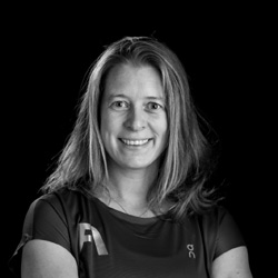 Frau lächelnd im Fitness-Shirt, symbolisiert gesunde Ernährung und aktiven Lebensstil.