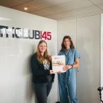 Zwei Frauen präsentieren ein Magazin von "HEALTHCLUB145", einer Ernährungsfirma.